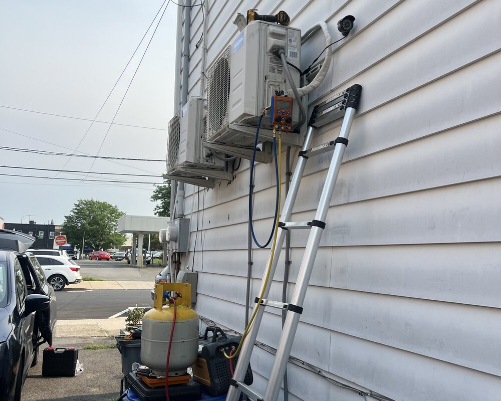 Mini-split installation service using a ladder and HVAC equipment